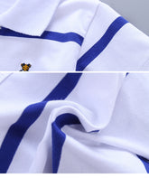 Boy wearing a navy college style short sleeve polo shirt by Bucciato, featuring a classic collar and button placket.