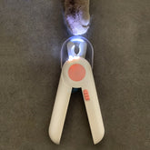 LED pet nail clipper with built-in light and ergonomic handle, designed for safe and precise trimming of dog or cat nails.