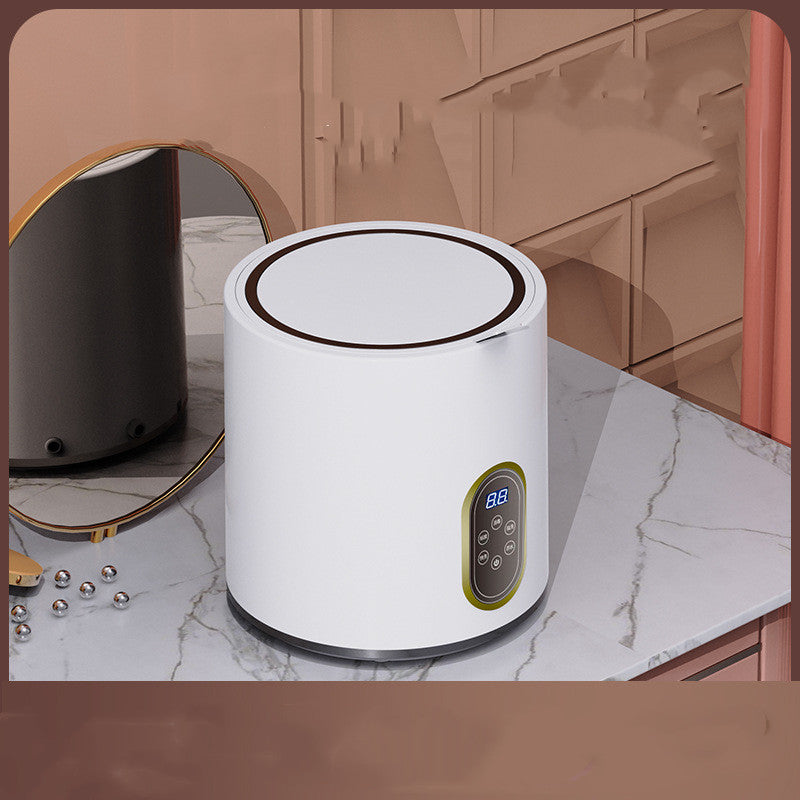 Mini automatic washing machine for children by Bucciato, compact white appliance with control panel and drum inside.