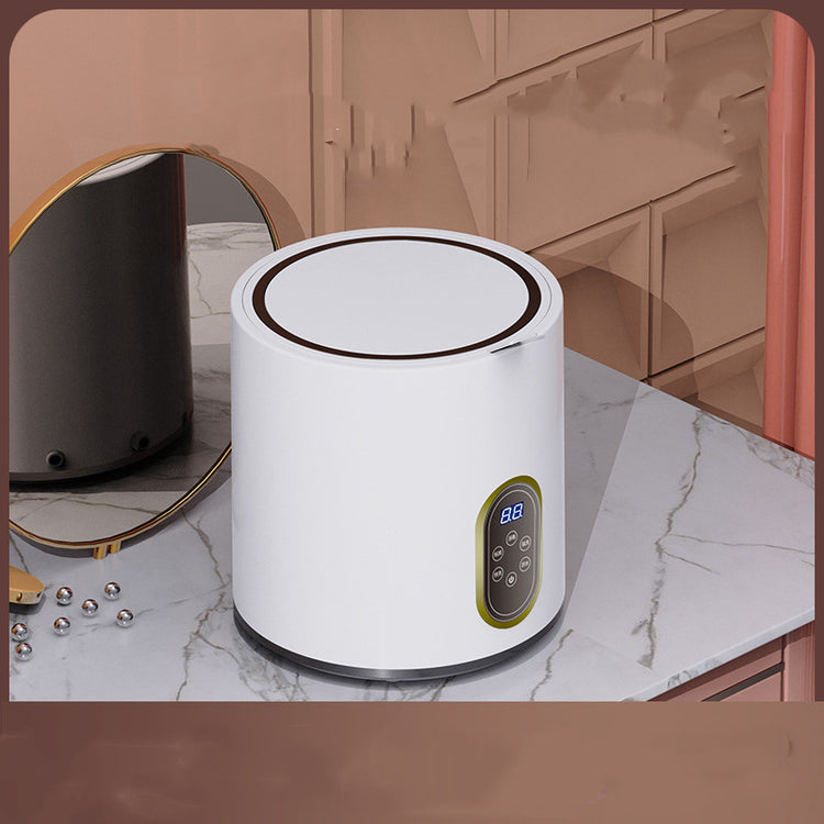 Mini automatic washing machine for children by Bucciato, compact white appliance with control panel and drum inside.