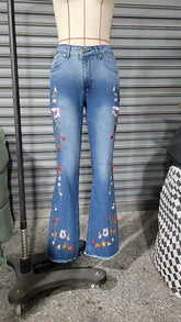 High-elasticity embroidered flared jeans for women, luxury designer denim with intricate embroidery, shown on a model.