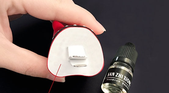 Bucciato Car air freshener clip with perfume scent attached to a vehicle air outlet for fresh interior air.
