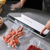 Small Bucciato household vacuum packaging machine with compact design and control panel for food preservation.