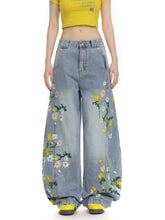 Luxury women’s embroidered denim jeans featuring floral and plant embroidery with a curved fit, from Bucciato.