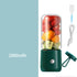 Mini electric portable juice machine from Bucciato, compact device with a transparent container and juicing blades visible.